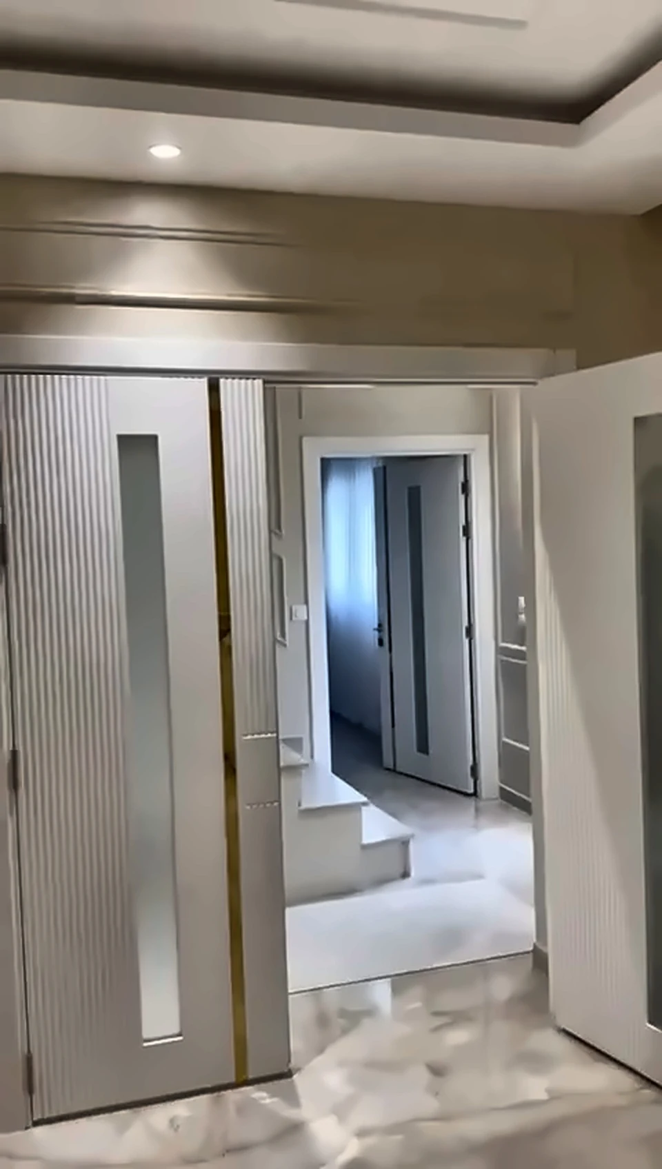 Pièce rénovée à Paris avec portes décoratives et éclairage encastré