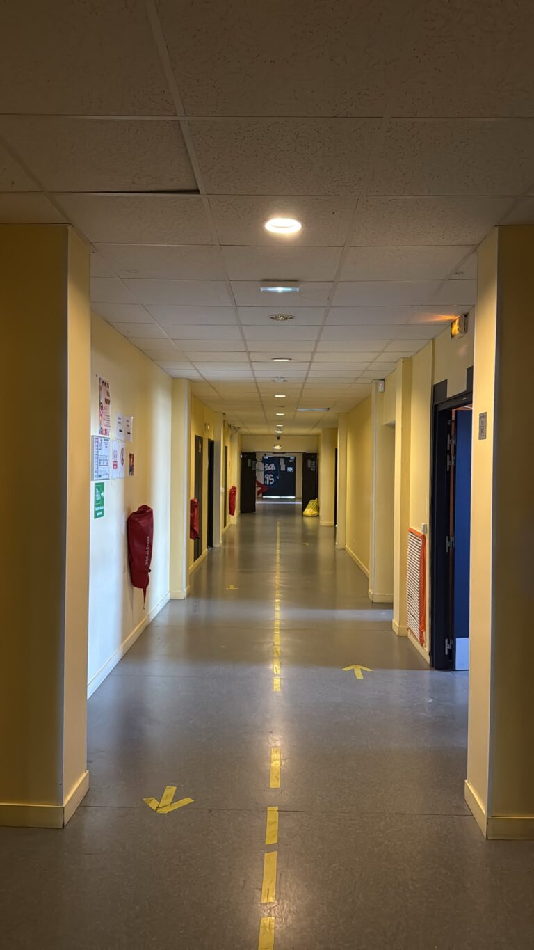 Couloir scolaire avant remplacement des anciens luminaires ronds