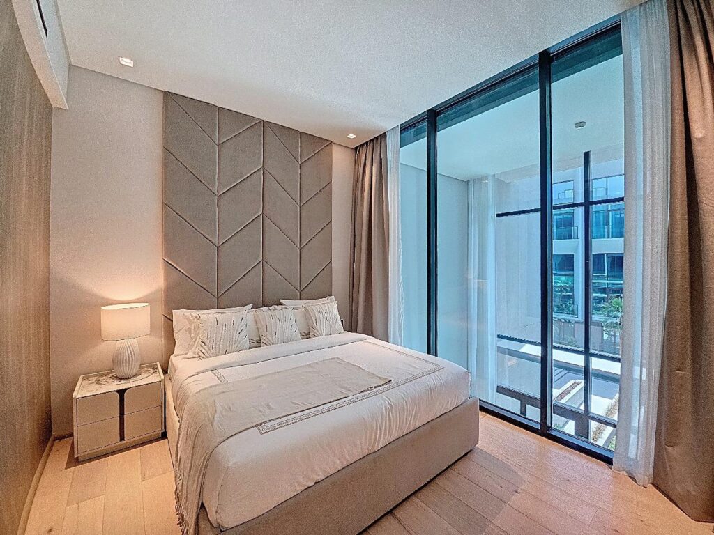 Chambre rénovée à Paris avec tête de lit textile et fenêtre pleine hauteur