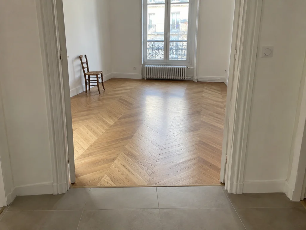 Exemple de pose de parquet et carrelage à Paris avec raccord de seuil soigné — vue 1